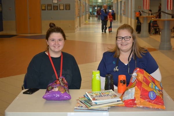 Senior Mackenzie Grope poses with Sydney Miller Snyder as they collect books during the 1st annual SADD NHS Trick or Treat